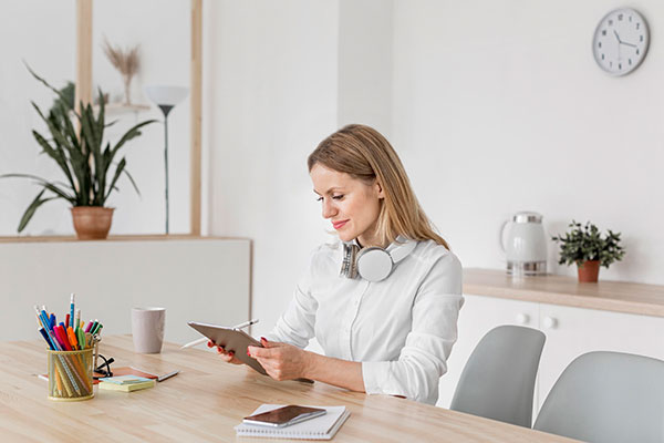 Frau mit Pad am Tisch sitzend erklärt